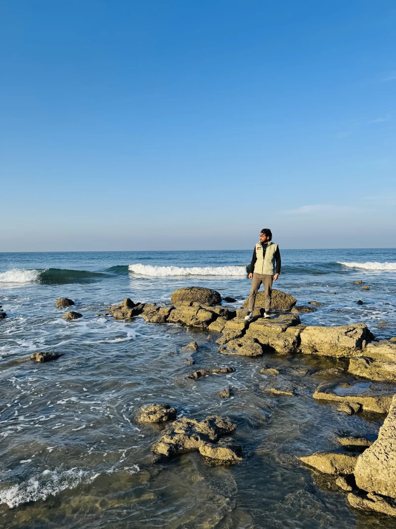 A traveler standing on the rocky shoreline at Cox’s Bazar