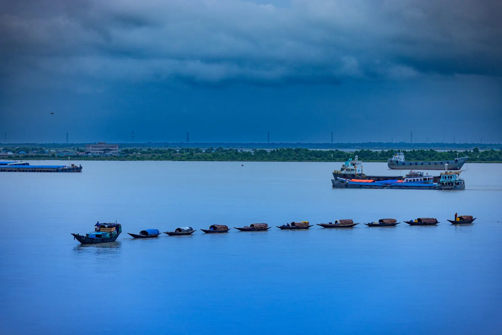 Fishing boats returning across a wide river near Khulna during the Sundarbans Tour