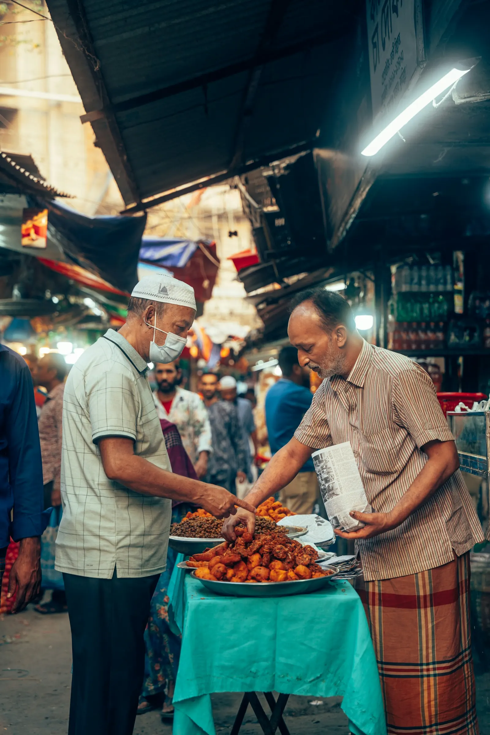 Local vendors serving food at a Bangladesh market stall, regional travel context for Chawkbazar