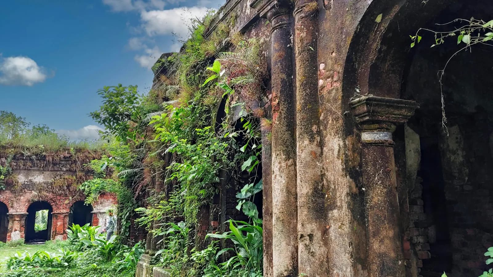 Historic brick arches overgrown with greenery in Rangpur, regional travel context for Panam Nagar