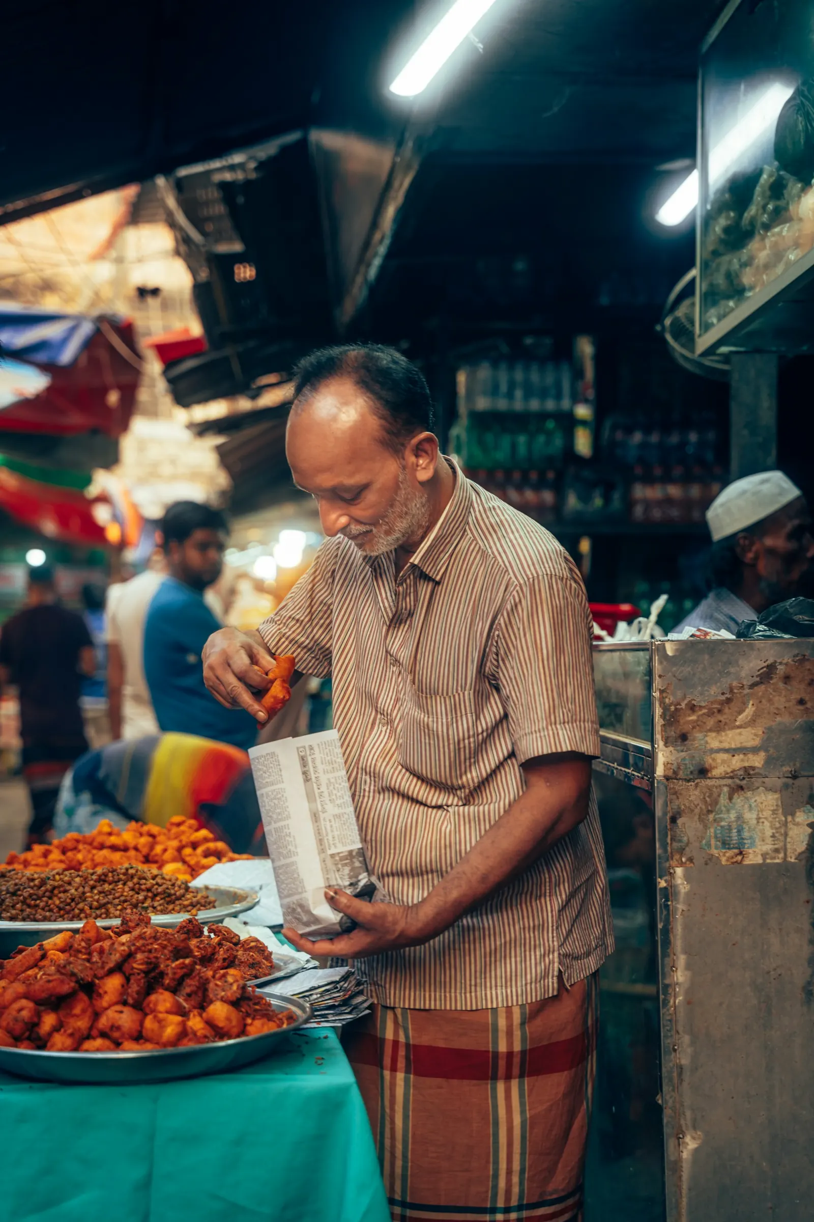 Street food vendor frying traditional snacks at a Bangladesh market during the Dhaka Food Tours