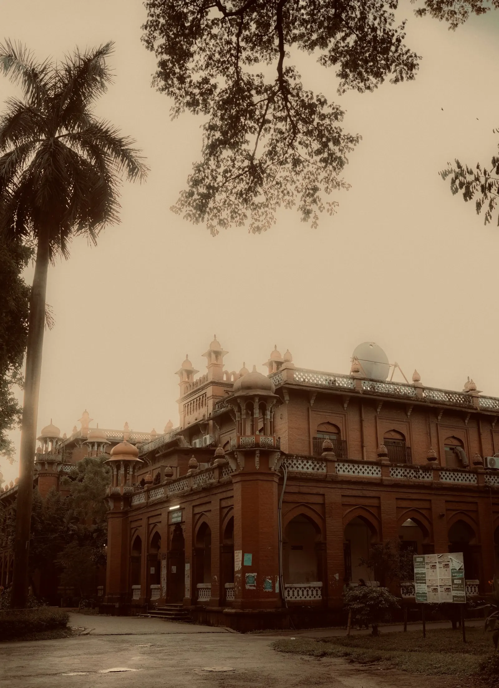 Historic brick building and palm tree in Dhaka during the Chittagong Shipyard Tour